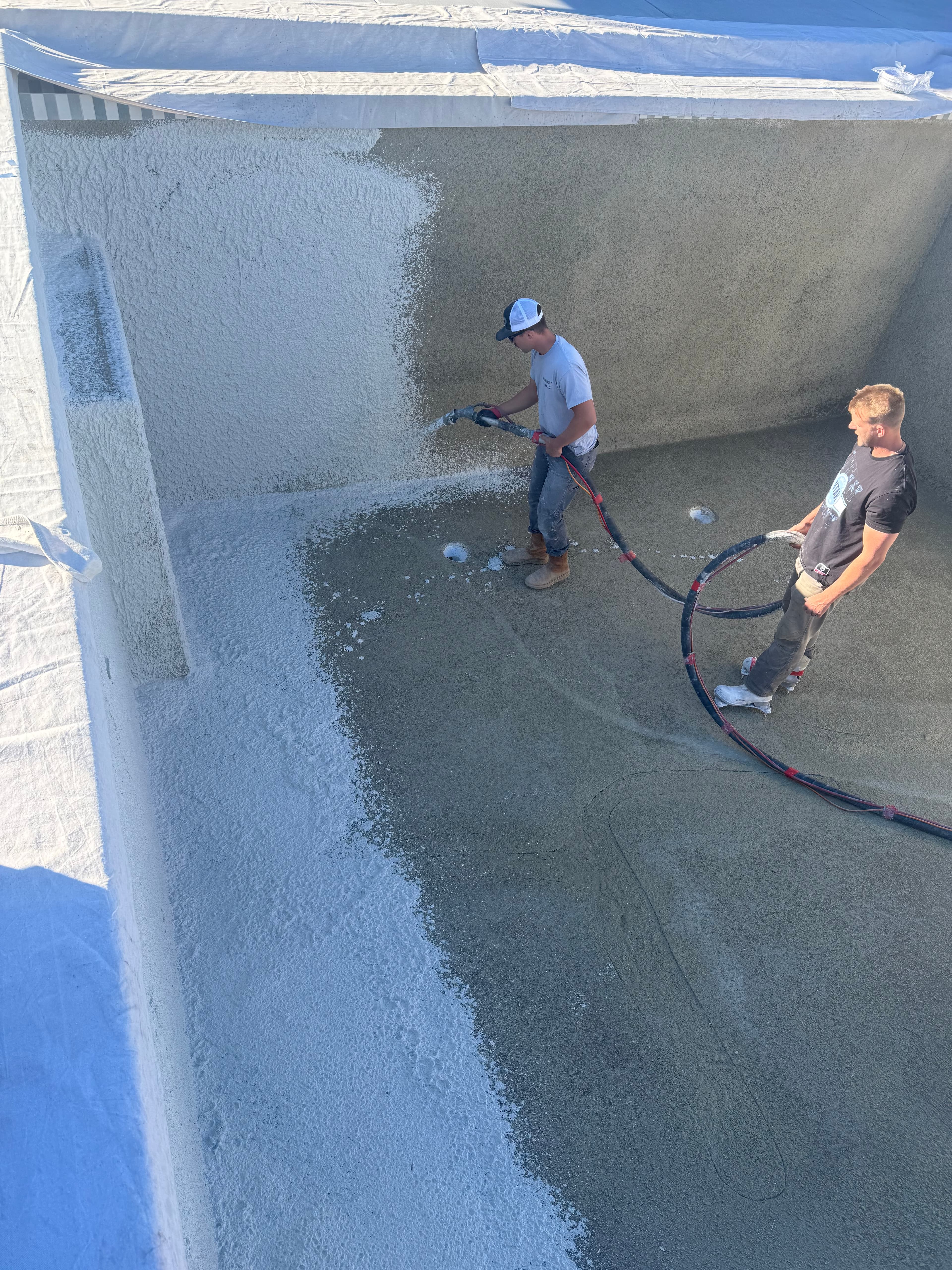 Farnsworth crew spraying plaster — overhead view of the job